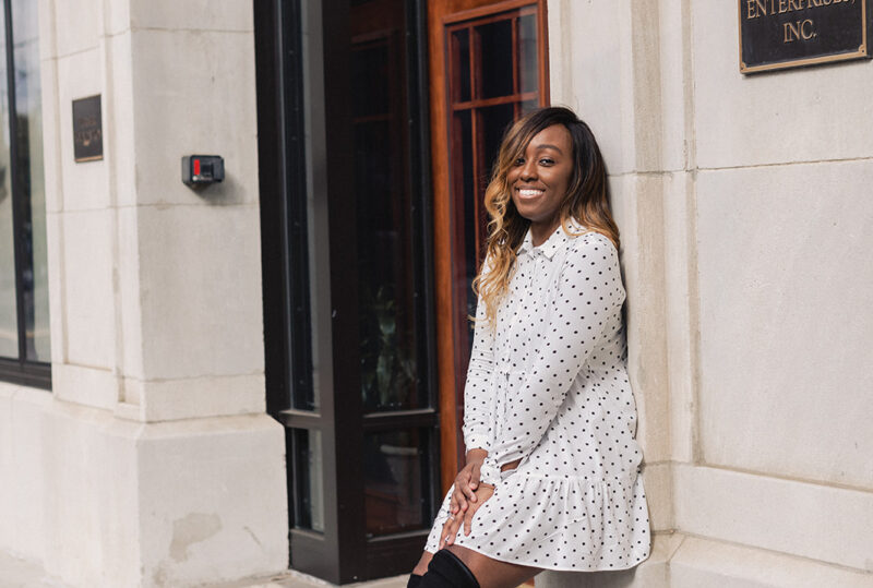 Jordan Taylor C - 6 Free Apps that EVERY Blogger Needs, black woman in white polka dot dress and stuart weitzman over the knee leaning against a wall